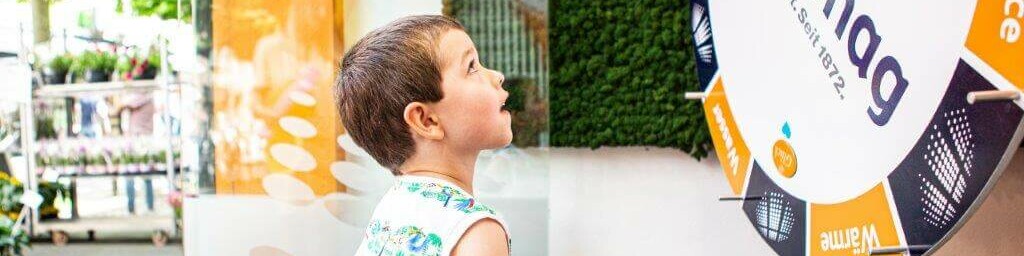 Nachhaltigkeit 2023 Kleiner Junge dreht an einem Gewinnspielrad.