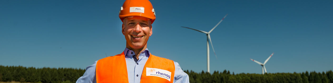 Mitarbeiter in Schutzkleidung vor einem Windrad Mitarbeiter in Schutzkleidung vor einem Windrad