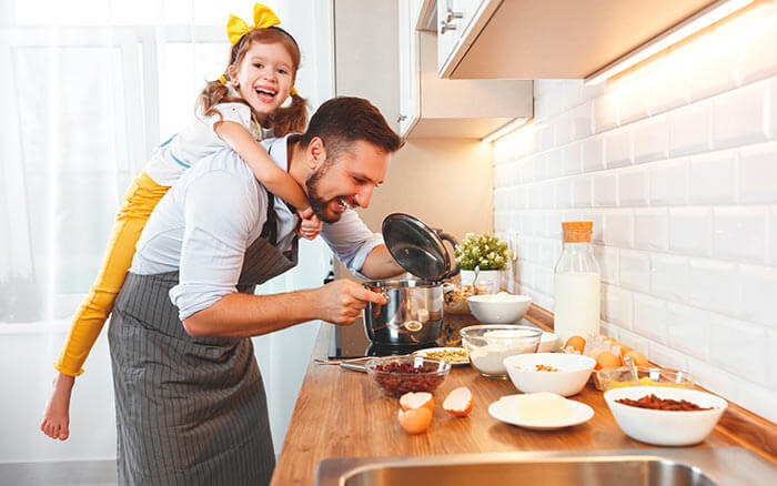 Ostern 02 Mann mit Kind huckepack in der Küche
