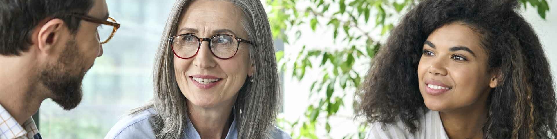 Vielfalt Ein Mann und zwei Frauen sprechen miteinander.