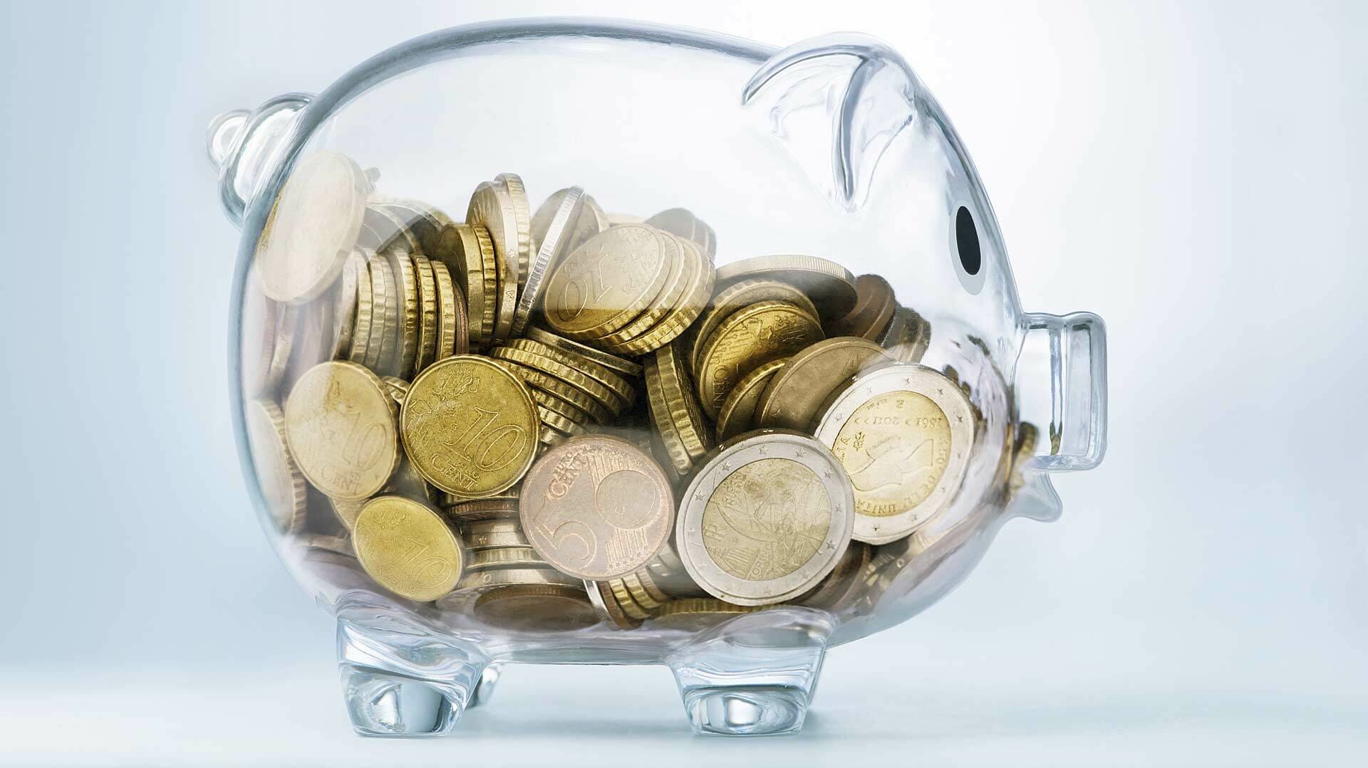 EEG Umlage Gläsernes Sparschwein mit Münzen drin