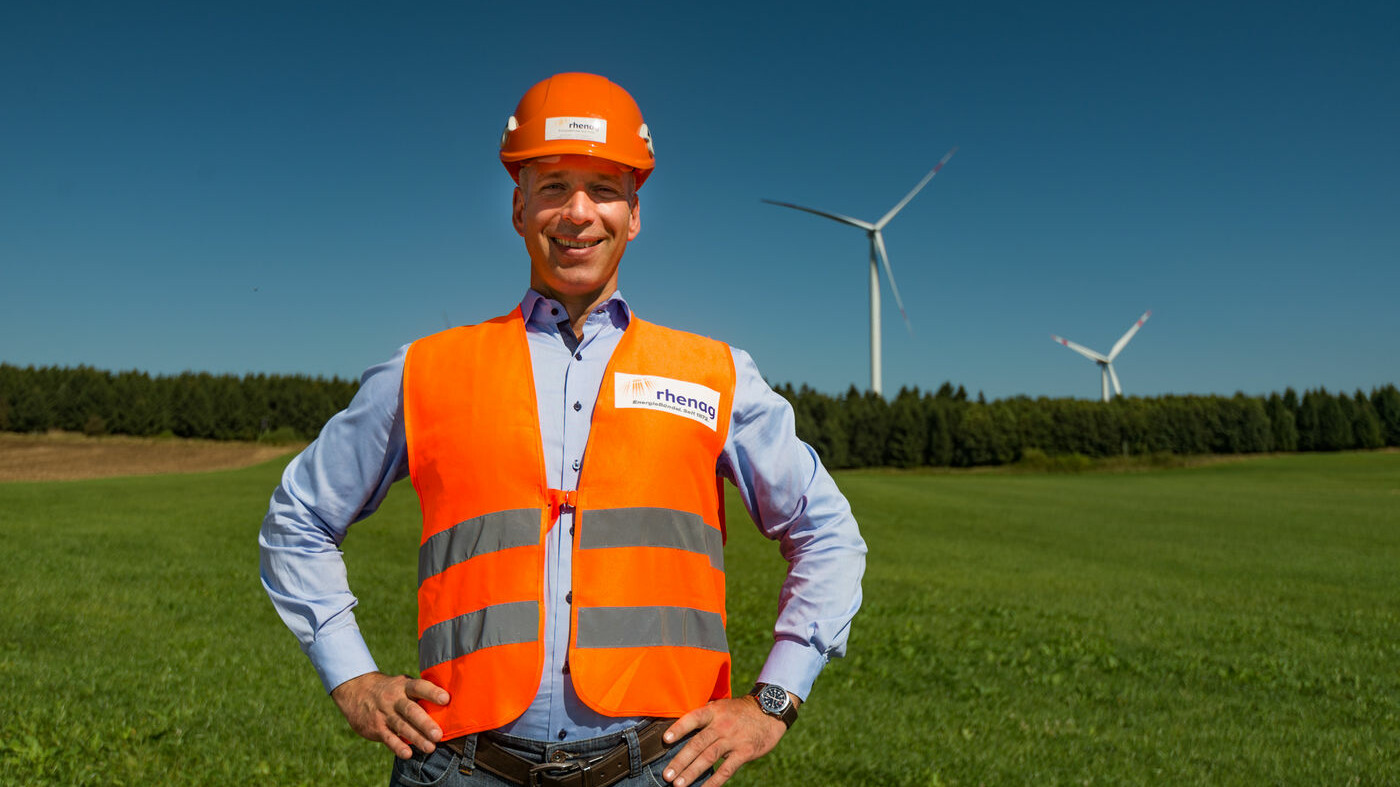 Mitarbeiter in Schutzkleidung vor einem Windrad Mitarbeiter in Schutzkleidung vor einem Windrad