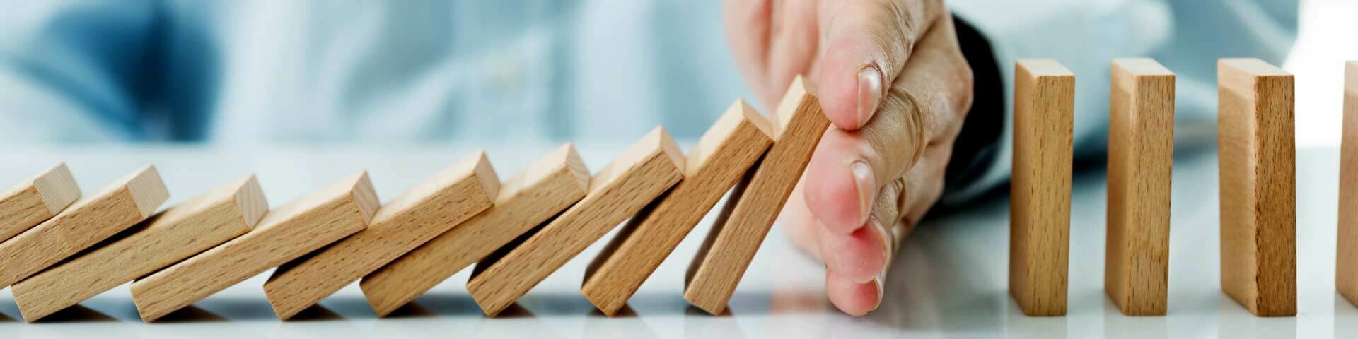 Energielieferung Hand hält umfallenden Dominosteine auf